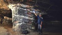 Foto mostrando o nível mineralizado composto por turmalinito e veios de quartzo-carbonato-turmalina-sulfeto. A foto também mostra a técnica de lavra do minério por abandono de pilar, utilizada na mina.