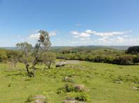 Vista dos campos da chácara do Forte os blocos de granito sobre os campos e ao fundo a serra do Segredo. Fotografia: Carlos Peixoto, 2013.