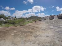 Visão geral do lajedo que possui enclaves dioríticos, mistura de magmas (mixing e mingling) e tanques com conteúdo fossílifero. Foto: Rogério Valença Ferreira.