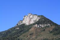 Vista do flanco norte da Pedra Branca que é utilizada como rota de escalada do sítio. O morro testemunho de 800 metros de altitude fica no município Praia Grande em Santa Catarina, sua litologia é formada de rochas vulcânicas da formação Serra Geral com idade Cretácea Inferior. (Autor: Michel Godoy/2011)